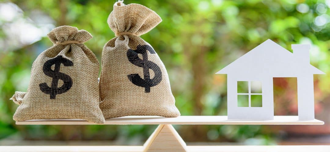 Money bags weighing next to a home.