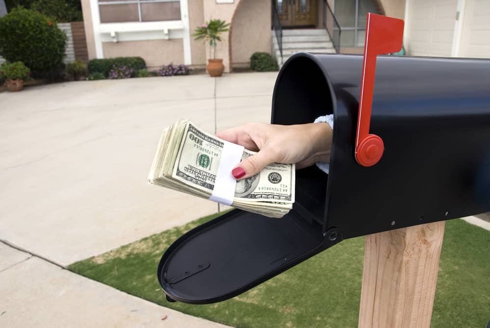 A bundle of cash is being delivered to a house
